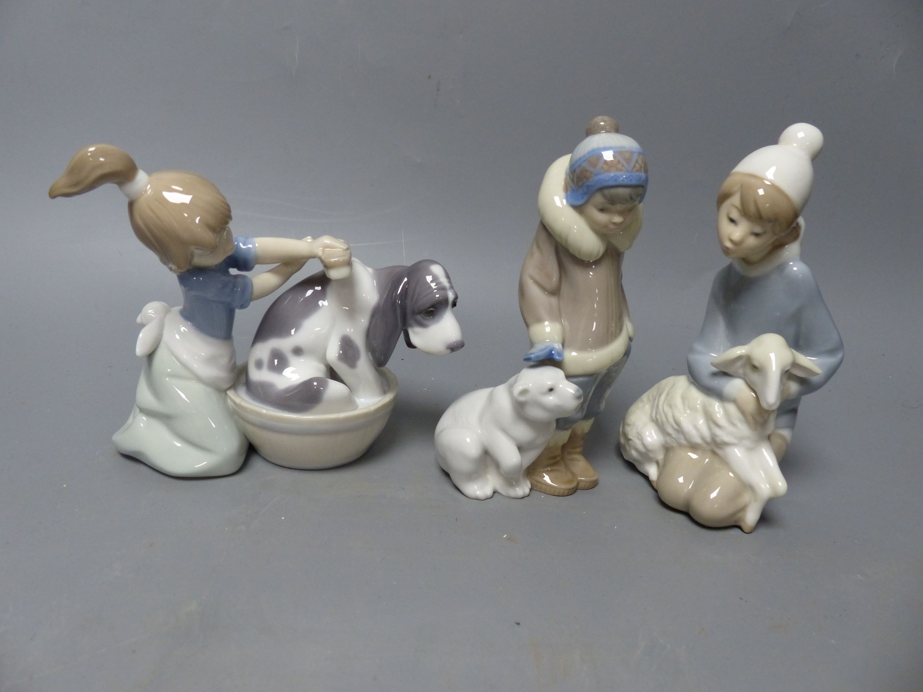 Seventeen Lladro figures of animals, or children holding animals